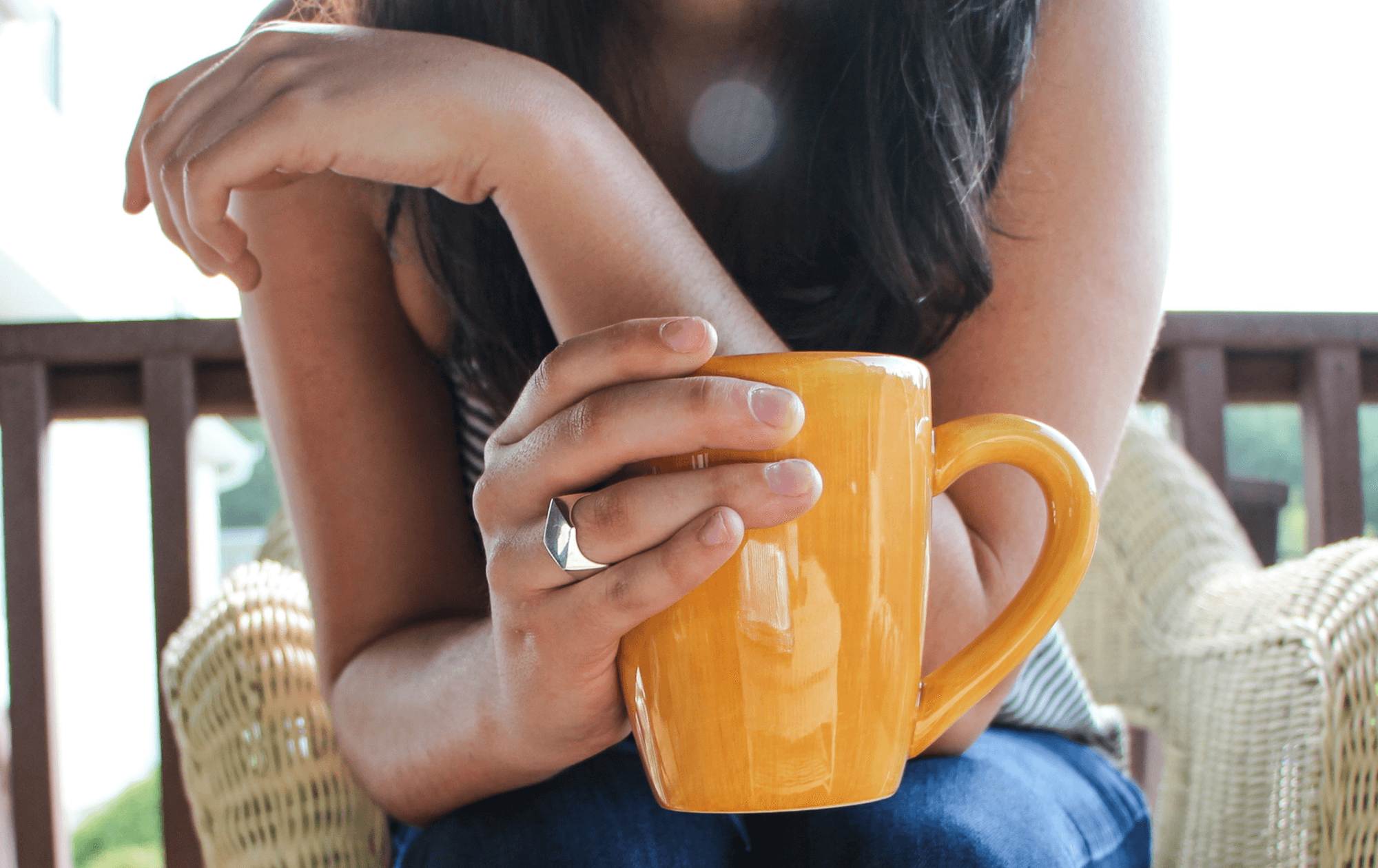 Girl holding ornage cup of coffee